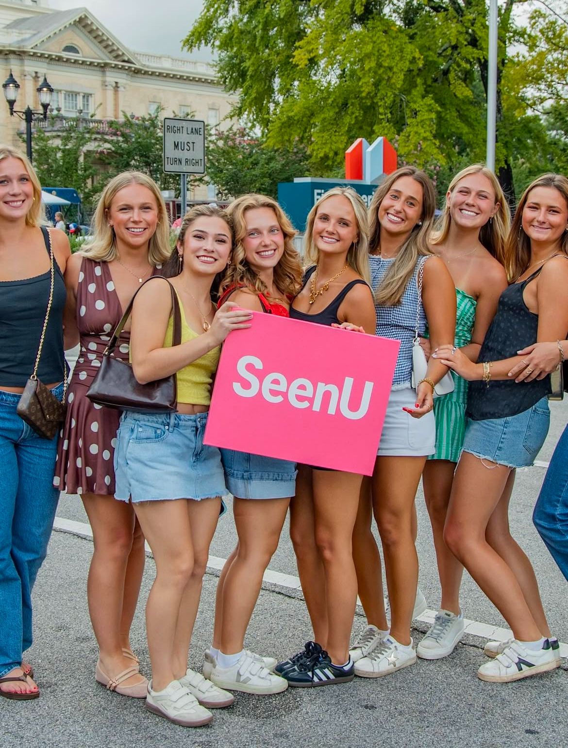 Some Girls holding a SeenU placard